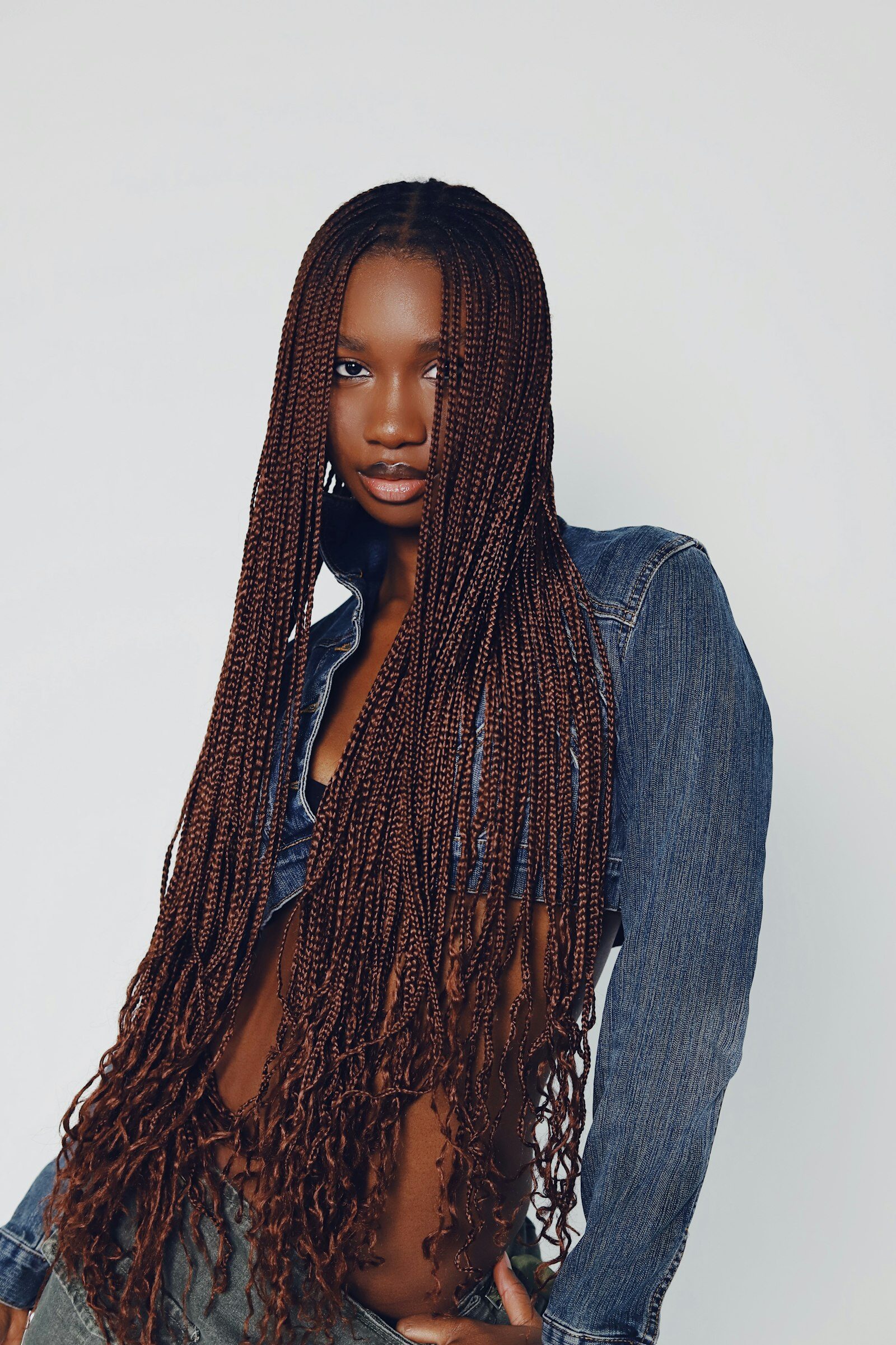 Woman with very long, fine braids wearing a denim shirt