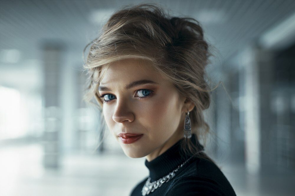 Woman with a short, tousled blonde cut looking towards the camera
